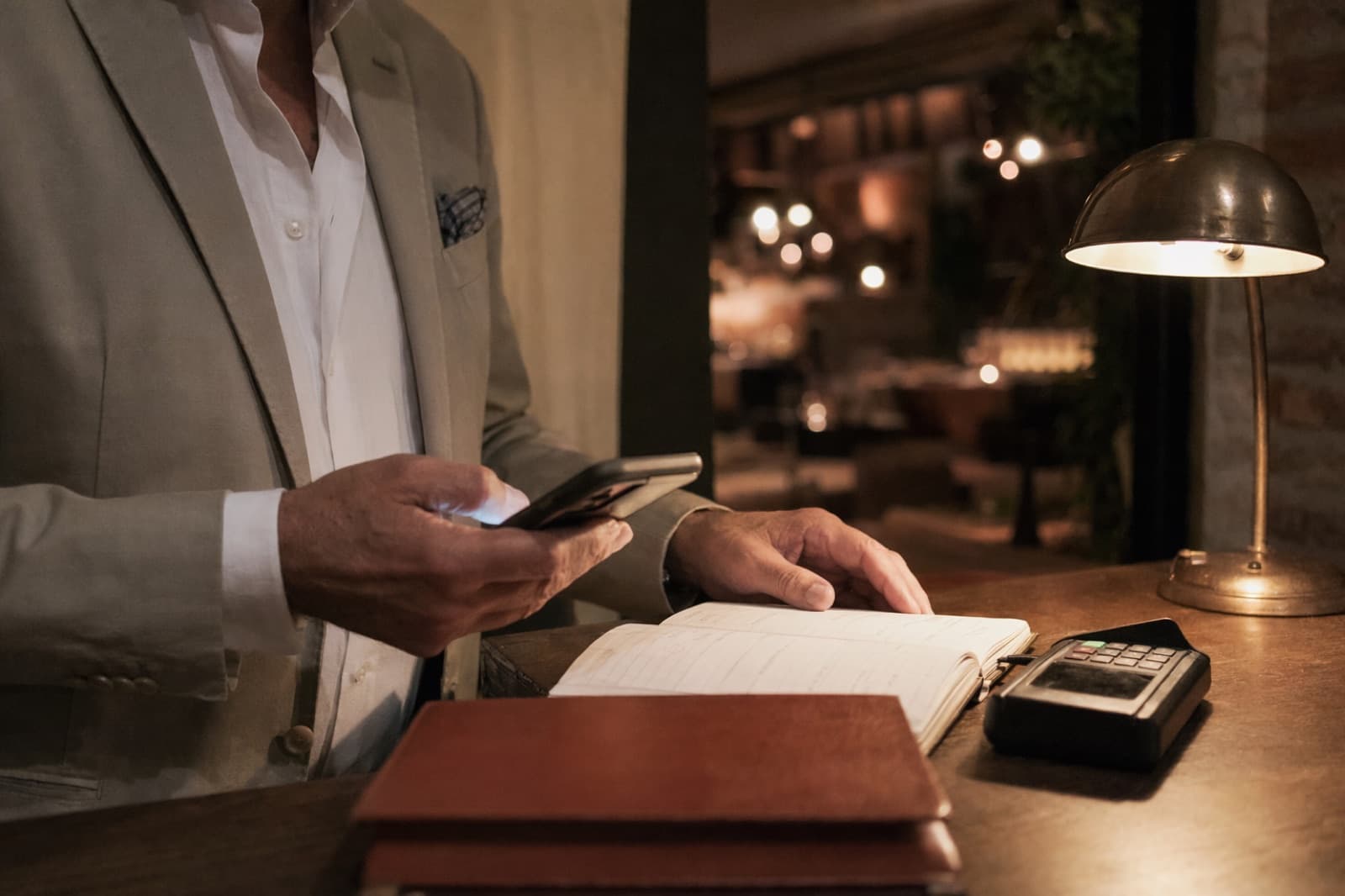 Il registro delle prenotazioni aperto sul bancone di un ristorante, con un tavolo da dieci cancellato all'ultimo momento un sabato di pienone